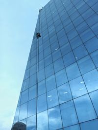 Low angle view of glass building against sky