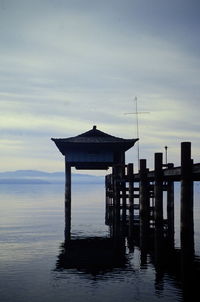 Pier on sea against sky during sunset