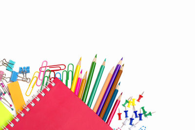 High angle view of multi colored pencils on white background
