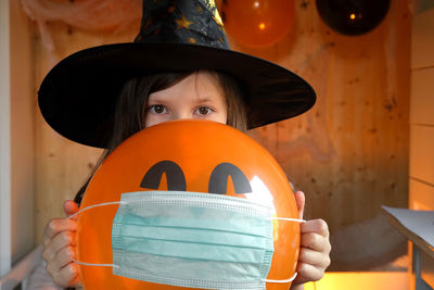 Halloween kids mask. teen girl in witch costume and black hat. child in protective medical mask