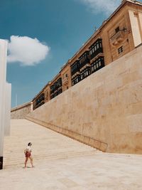 Full length of man standing by building against sky