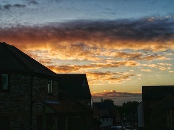 Houses against sky during sunset