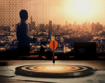 Rear view of boy standing by table