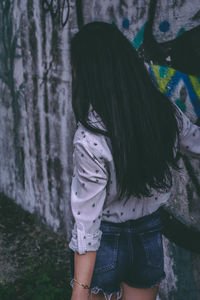 Rear view of woman standing by tree