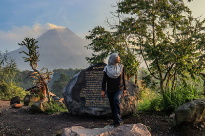 Rear view of woman on rock