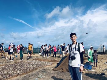 People standing on beach against sky