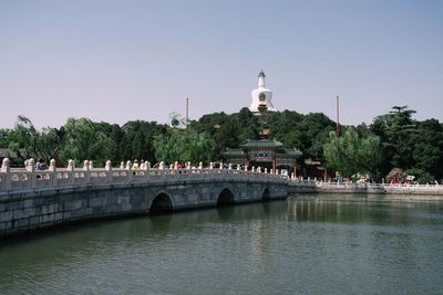 Bridge over river in city against clear sky