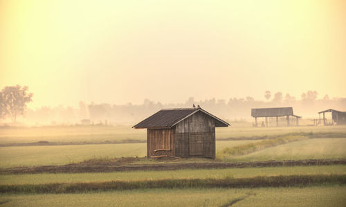 Barn on field against sky