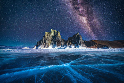 Scenic view of frozen lake against star field at night