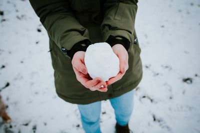 Close-up of hands holding a snowball