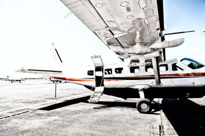 Airplane on airport runway against sky