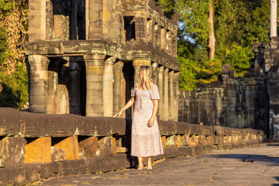 Rear view of woman standing against building