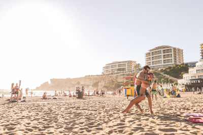 People on beach against clear sky