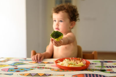 Portrait of boy sitting on table