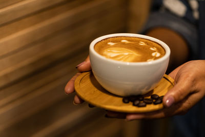 Man holding coffee cup on table