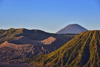 Scenic view of volcanic landscape against clear blue sky