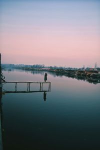 Man by lake during sunset