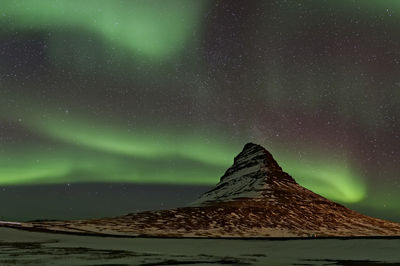 Scenic view of snowcapped mountain against sky at night