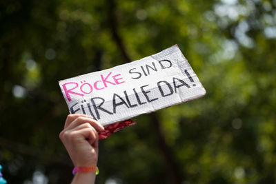 Close-up of hand holding cardboard with text