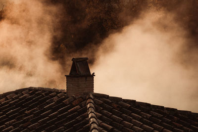 Rooftop of building against cloudy sky