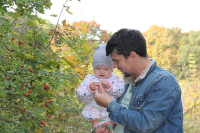 Father and daughter against plants