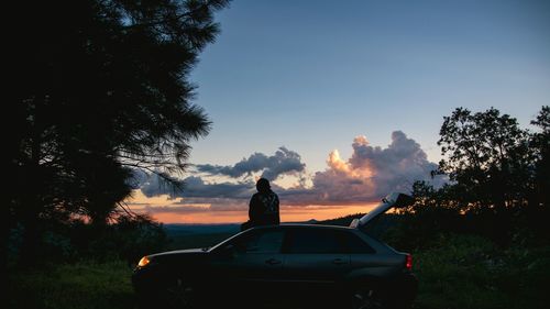 People on car against sky during sunset