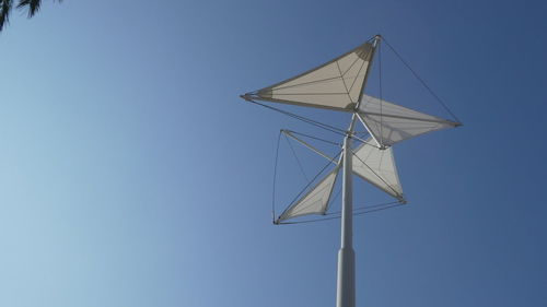 Low angle view of windmill against clear blue sky