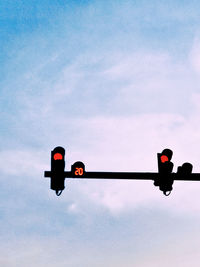 Low angle view of road signal against sky