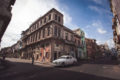 Cars on street in front of cathedral against sky