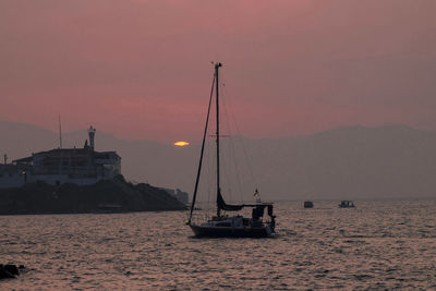 Sailboats sailing on sea against sky during sunset