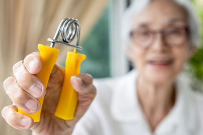 Close-up of senior woman holding squeezing equipment