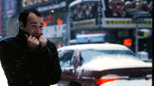 Man shivering during snowfall in city