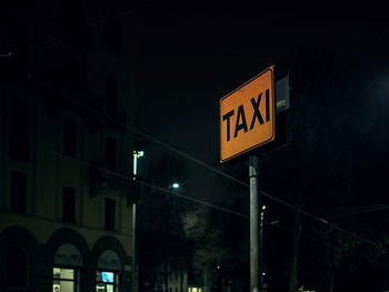 Low angle view of information sign at night