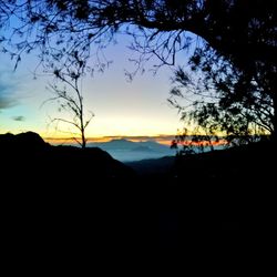 Scenic view of silhouette mountains against sky at sunset