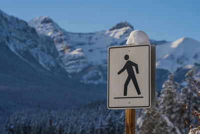 Information sign on snowcapped mountain