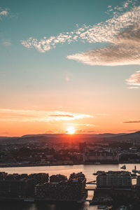 Scenic view of sea and buildings against sky during sunset