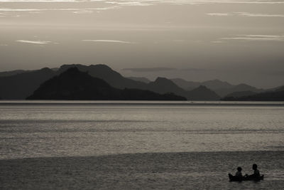 Scenic view of sea and mountains against sky