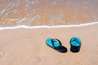 High angle view of shoes on sand at beach