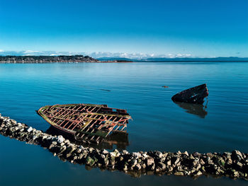 High angle view of groyne in sea against blue sky