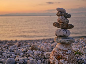 Stack of stones on beach during sunset