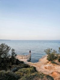 Man looking at sea against clear sky