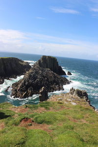 Scenic view of rocks on beach against sky