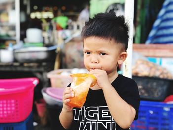 Close-up of boy having drink while standing outdoors