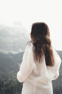 Rear view of woman standing against mountain