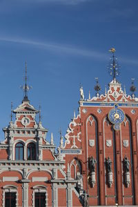 Low angle view of house of the blackheads at town square against blue sky