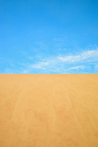 Scenic view of desert against blue sky