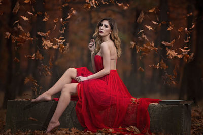 Young woman looking away while sitting outdoors