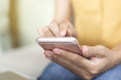 Midsection of man using mobile phone