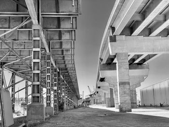 Low angle view of elevated road amidst buildings against sky