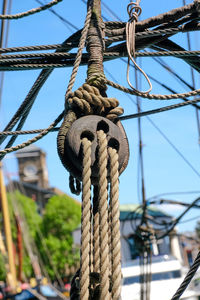 Low angle view of rope on pulley against clear blue sky